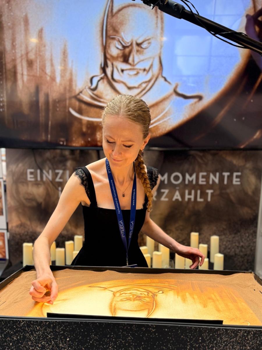 Olga während ihres Live-Sandmalerei-Auftritts auf dem INTHEGA Theatermarkt 2026.